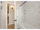 Bathroom featuring a white marbled tile shower with a built-in shelf and a view into the doorway at 34515 N 142Nd St, Scottsdale, AZ 85262