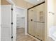 A well-lit bathroom featuring a glass enclosed shower, tile floors, and access to a spacious walk-in closet at 34515 N 142Nd St, Scottsdale, AZ 85262