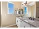 Bright bathroom featuring a double granite vanity, modern lighting and a well-lit window with a blue sky view at 34515 N 142Nd St, Scottsdale, AZ 85262