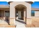 Welcoming front entrance featuring an arched porch, stone accents, and a stylish front door at 34515 N 142Nd St, Scottsdale, AZ 85262