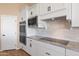 This kitchen features white cabinets, stainless steel appliances, granite countertops, and modern black hardware at 34515 N 142Nd St, Scottsdale, AZ 85262