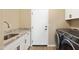 Clean laundry room featuring a granite countertop, undermount sink, washer/dryer and white cabinets at 34515 N 142Nd St, Scottsdale, AZ 85262