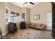 A comfortable sitting area with large windows, tile floors, a stylish rug, and modern furniture create a cozy space at 34515 N 142Nd St, Scottsdale, AZ 85262