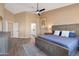 A bright main bedroom featuring tile floors, neutral paint, a ceiling fan, and access to the main bathroom at 34515 N 142Nd St, Scottsdale, AZ 85262