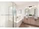 Beautiful bathroom showcasing a glass-enclosed shower and soaking tub adjacent to a double sink vanity at 379 W Dragon Tree Ave, Queen Creek, AZ 85140