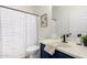 Well-appointed bathroom with a blue vanity, white sink, and a shower featuring a striped curtain at 379 W Dragon Tree Ave, Queen Creek, AZ 85140