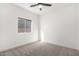 Bright bedroom featuring neutral carpet, a ceiling fan, and a large window bringing in natural light at 379 W Dragon Tree Ave, Queen Creek, AZ 85140