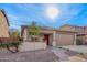 Inviting single-story home with desert landscaping, a covered front porch and a brick walkway at 379 W Dragon Tree Ave, San Tan Valley, AZ 85140