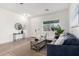 Bright living area with a large window, modern furniture, and light hardwood floors at 379 W Dragon Tree Ave, San Tan Valley, AZ 85140