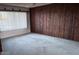 Cozy living room featuring classic wood paneling and ample natural light at 3934 E Sahuaro Dr, Phoenix, AZ 85028