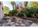 Beautiful backyard featuring a stone fire pit, desert landscaping, and mature shade trees at 3954 E Florian Ave, Mesa, AZ 85206