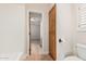 Bathroom featuring a white toilet, dark wood storage cabinet and view into a carpeted bedroom at 3954 E Florian Ave, Mesa, AZ 85206