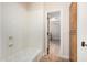 Bathroom with a white tub/shower combination, dark wood cabinet and view into a carpeted bedroom at 3954 E Florian Ave, Mesa, AZ 85206