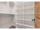 White closet with an open door, white shelving, a pole and a carpeted floor at 3954 E Florian Ave, Mesa, AZ 85206