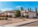 View of the house showcasing the three-car garage, neutral color scheme and well-manicured desert landscape at 3954 E Florian Ave, Mesa, AZ 85206