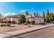 View of the house showcasing the three-car garage, neutral color scheme and well-manicured desert landscape at 3954 E Florian Ave, Mesa, AZ 85206