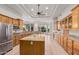 Well-lit kitchen featuring a large island, wooden cabinetry, and modern appliances at 3954 E Florian Ave, Mesa, AZ 85206