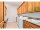 Laundry room features laundry machines, a sink, a laminate countertop, storage cabinets and a tile floor at 3954 E Florian Ave, Mesa, AZ 85206