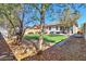 Backyard with artificial turf, decorative trees and foliage, a pergola, and a hot tub at 40716 N Hudson Trl, Anthem, AZ 85086