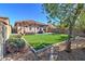 Landscaped backyard featuring artificial turf, an outdoor kitchen, and mature trees at 40716 N Hudson Trl, Anthem, AZ 85086