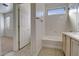 Bright bathroom features a tub-shower combination, a vanity, and an entrance to the bedroom at 40716 N Hudson Trl, Anthem, AZ 85086