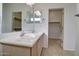 Well-lit bathroom featuring dual sinks, tile flooring, and a view of a walk-in closet at 40716 N Hudson Trl, Anthem, AZ 85086