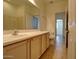 A well-lit bathroom features a large mirror and double sinks with a view to the next room at 40716 N Hudson Trl, Anthem, AZ 85086