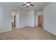 Large bedroom showcasing carpet, a ceiling fan, and entrances to the closet and bathroom at 40716 N Hudson Trl, Anthem, AZ 85086