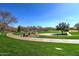 Enjoy the outdoors with sidewalks, lush green grass, trees, and blue skies in this community park at 40716 N Hudson Trl, Anthem, AZ 85086