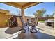 Relaxing covered patio with a dining table, chairs, and a grill, ideal for outdoor entertaining at 40716 N Hudson Trl, Anthem, AZ 85086