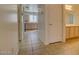 A tiled hallway with a view of the kitchen featuring light wood cabinets and tile backsplash at 40716 N Hudson Trl, Anthem, AZ 85086