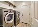 Laundry room features a modern washer and dryer set with overhead storage shelves at 40716 N Hudson Trl, Anthem, AZ 85086