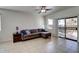 Comfortable living room featuring tile floors, a ceiling fan, and a sliding glass door to the backyard at 40716 N Hudson Trl, Anthem, AZ 85086