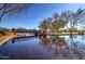 Tranquil pond reflecting a bridge and trees under a clear blue sky for a scenic view at 40716 N Hudson Trl, Anthem, AZ 85086