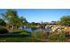 Serene pond with decorative waterfalls surrounded by lush greenery in a well maintained park at 40716 N Hudson Trl, Anthem, AZ 85086