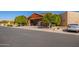 Community clubhouse entrance showcasing wooden beams, tiled roof, and a parked car nearby at 4202 E Broadway Rd # 211, Mesa, AZ 85206