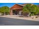 Community clubhouse entrance featuring wooden beam accents, tiled roof, and landscaped surroundings at 4202 E Broadway Rd # 211, Mesa, AZ 85206