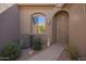 Front entrance featuring desert landscaping, an AC unit, security door, and an arched window at 4202 E Broadway Rd # 211, Mesa, AZ 85206