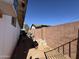 Side yard with secure brick wall, offering privacy and potential for storage or garden space at 451 E Franklin Ave, Mesa, AZ 85204