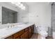 Bathroom featuring a double sink vanity with a granite countertop and white toilet next to the bathtub at 5226 W Freeway Ln, Glendale, AZ 85302