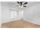 Bright bedroom features tile flooring, ceiling fan, and window for natural light at 5226 W Freeway Ln, Glendale, AZ 85302