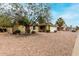 Single story home with desert landscaping in the front yard and large shade tree at 5226 W Freeway Ln, Glendale, AZ 85302