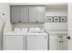 Well-organized laundry room with modern gray cabinets, sleek countertop, and efficient washer/dryer units at 5232 E Everett Dr, Scottsdale, AZ 85254