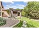 Charming backyard with a stone-lined grass path leading to a covered patio and beautiful landscaping at 5636 E Libby St, Scottsdale, AZ 85254