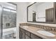 Well-lit bathroom featuring a granite countertop, dual sinks and a tiled shower at 5636 E Libby St, Scottsdale, AZ 85254