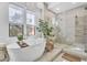 Bright bathroom featuring a soaking tub, glass shower, and elegant fixtures at 5636 E Libby St, Scottsdale, AZ 85254