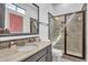 Bathroom with a dark vanity, granite countertop, framed mirror and glass door shower at 5636 E Libby St, Scottsdale, AZ 85254