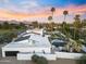 Aerial view of a desert home showcasing the lush backyard, pool, and surrounding landscape at dusk at 6601 E Hearn Rd, Scottsdale, AZ 85254