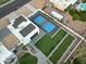 Aerial daytime view of backyard featuring a sport court, putting green, solar panels and lush landscaping at 6601 E Hearn Rd, Scottsdale, AZ 85254