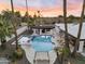 Aerial daytime view of the backyard showcasing a sparkling pool, covered patio, desert landscaping, and lounge area at 6601 E Hearn Rd, Scottsdale, AZ 85254